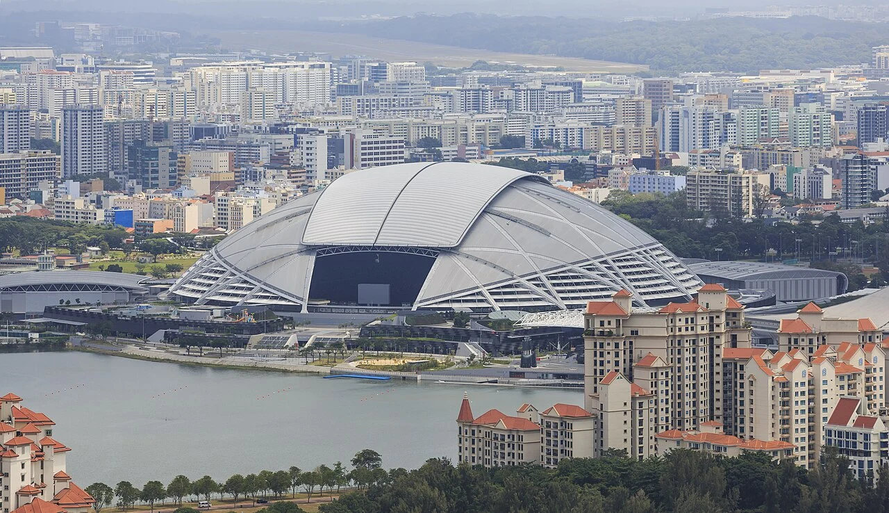Singapore National Stadium and Sports Hub seen from above against the city skyline.